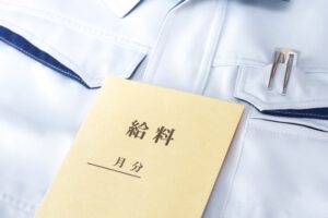 作業服の上に置かれた給料袋