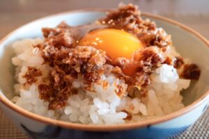 ご飯茶碗におかかと黄身が乗っている様子