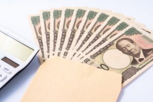 封筒に入った一万円札と電卓