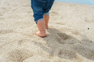 砂浜を歩く子どもの足元