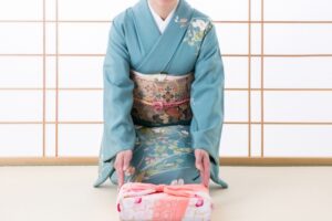 着物姿の女性が進物をする様子